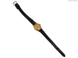 une image représentant une montre en or avec un bracelet noir