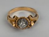 a close up of a gold ring with a diamond in the center