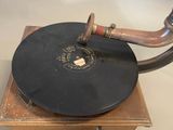 a black record on a wooden stand with a wooden handle