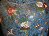 a blue vase with flowers and birds painted on it