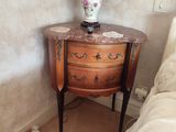 une table sur laquelle est posée une lampe, à côté d'un lit