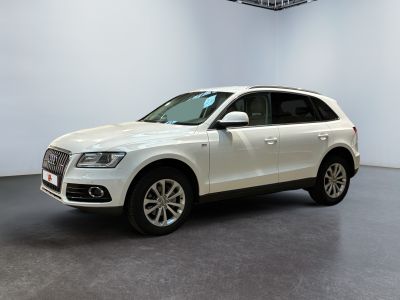 un SUV Audi blanc garé dans une grande pièce
