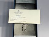 a box with a silver necklace and a card in it