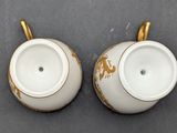 pair of white and gold vases with a dragon on them