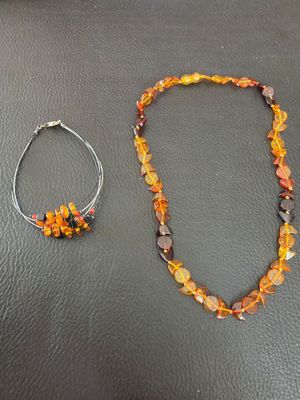 two pieces of jewelry are sitting on a black leather surface