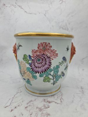 a vase with flowers painted on it sitting on a table