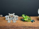 three glass figurines sitting on a wooden table