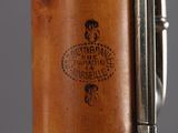 a close up of a rifle with a wooden handle and a label on it