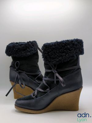the woman is wearing a pair of wedged boots with fur on them