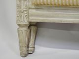 a white couch with a yellow and white striped upholstered