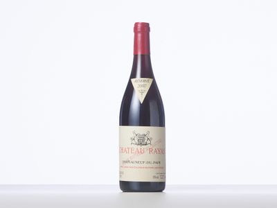 a bottle of red wine sitting on top of a white table