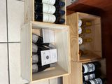 plusieurs bouteilles de vin dans une caisse en bois accrochée au mur