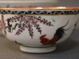 a white bowl with a black and red design on it
