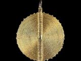 a close up of a piece of gold on a black background