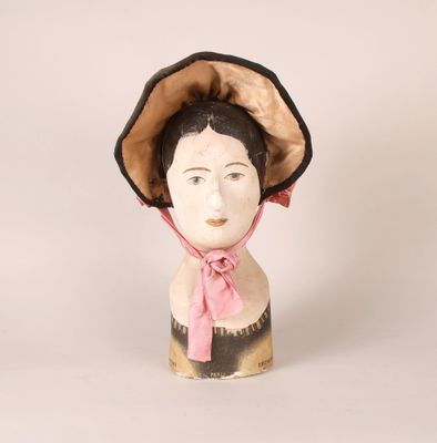 a ceramic head of a woman wearing a pink hat