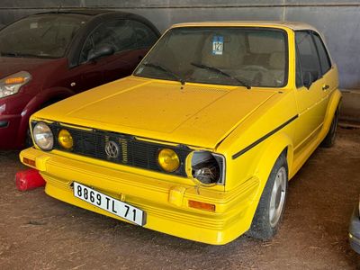 une voiture jaune garée à côté d'une voiture rouge dans un garage