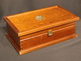 an old wooden box sitting on a grey cloth covered surface