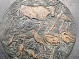 une image représentant une plaque métallique sur laquelle figurent un cerf et des flamants roses