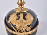 a black and gold vase with a gold bird on it