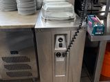 Plusieurs assiettes sont empilées sur un plan de travail dans la cuisine d'un restaurant.
