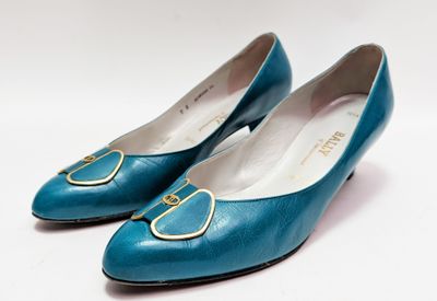 paire de chaussures bleues pour femme avec des boucles dorées sur fond blanc