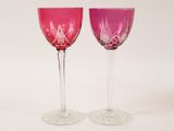 pair of pink wine glasses sitting on top of a white table
