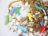 a lot of necklaces and bracelets on a white surface