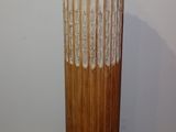 a tall vase sitting on top of a wooden stand