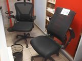 two black office chairs in a room with a red wall