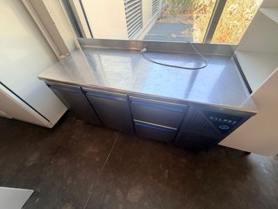 a kitchen with a stainless steel counter top and a window