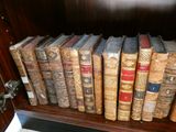 de nombreux livres anciens posés sur une étagère dans une pièce