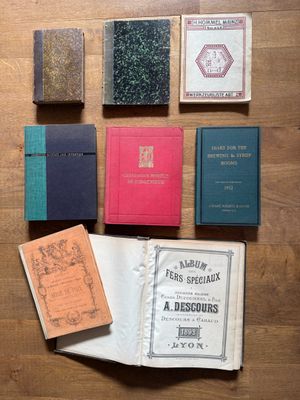 several books on a wooden table with one open and the other closed
