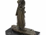 statue en bronze représentant un homme et une femme debout sur une bûche