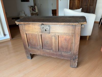 un coffre en bois posé sur un parquet dans un salon