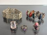 several different rings and bracelets are sitting on a table
