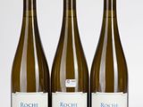 trois bouteilles de vin sont alignées sur une surface blanche