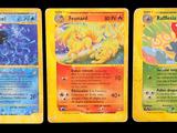trois cartes Pokémon présentant des motifs différents sur un fond noir