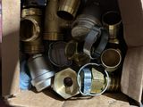 a cardboard box full of brass pipes and fittings