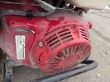a close up of a red motor bike with a small blower