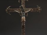 a close up of a metal cross with a person on it