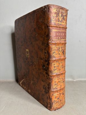 un vieux livre posé sur une table à côté d'un mur