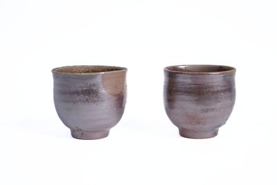 une paire de tasses marron et blanches sur fond blanc
