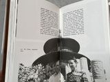 an open book with a black and white photo of a man wearing a hat
