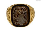 une image représentant une bague dorée et noire ornée d'un lion