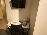 a small desk with a tv on it in a small room