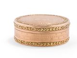 l'image d'une petite boîte en or sur laquelle repose une pièce de monnaie