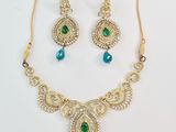 un ensemble composé d'un collier et de boucles d'oreilles ornés de pierres vertes