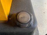 a close up of a yellow machine on a cement floor