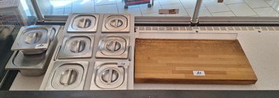 Plusieurs plateaux de nourriture sont posés sur un comptoir devant une porte vitrée