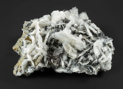 un gros plan d'une pierre recouverte de cristaux blancs sur fond noir